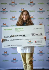 Juliet holding an oversized check