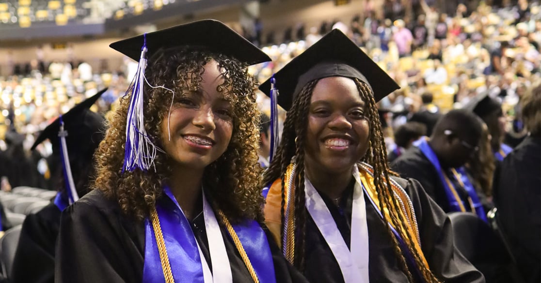 Florida Virtual High School Class of 2026 Graduation Checklist Two Florida Virtual High School seniors in their caps and gowns smile at the camera during their graduation ceremony.