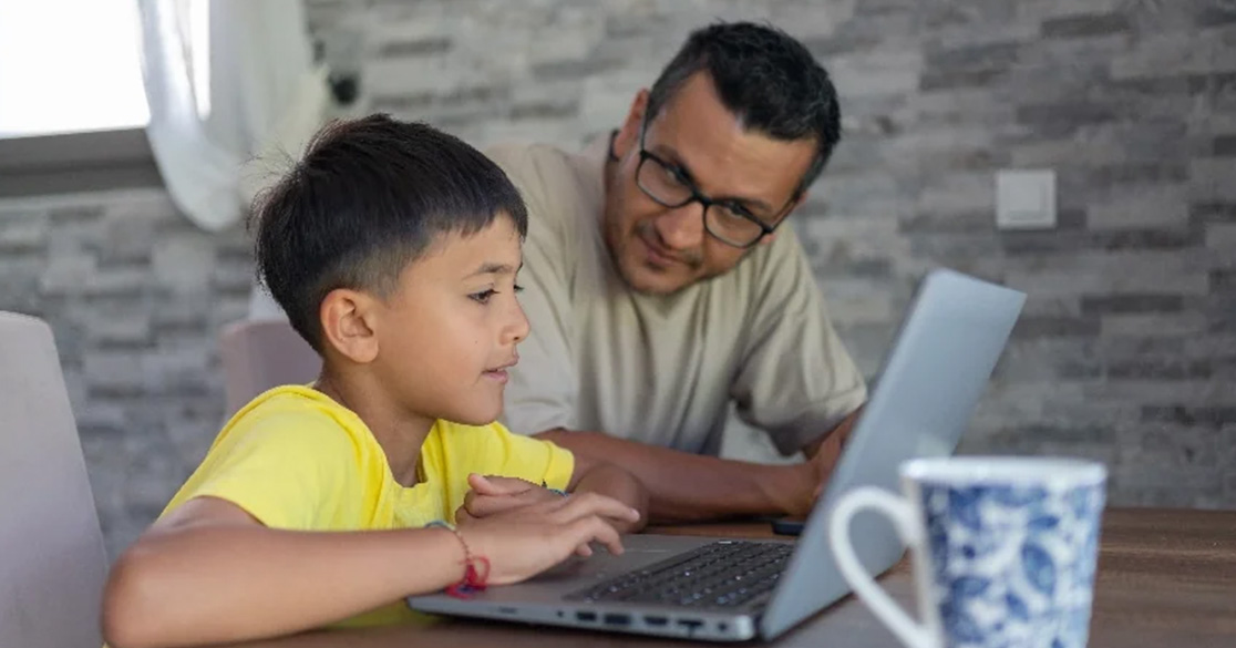 FLVS Enhances Family Engagement, Earns Recognition for Communications Excellence An adult and a child look at a laptop computer together at a table