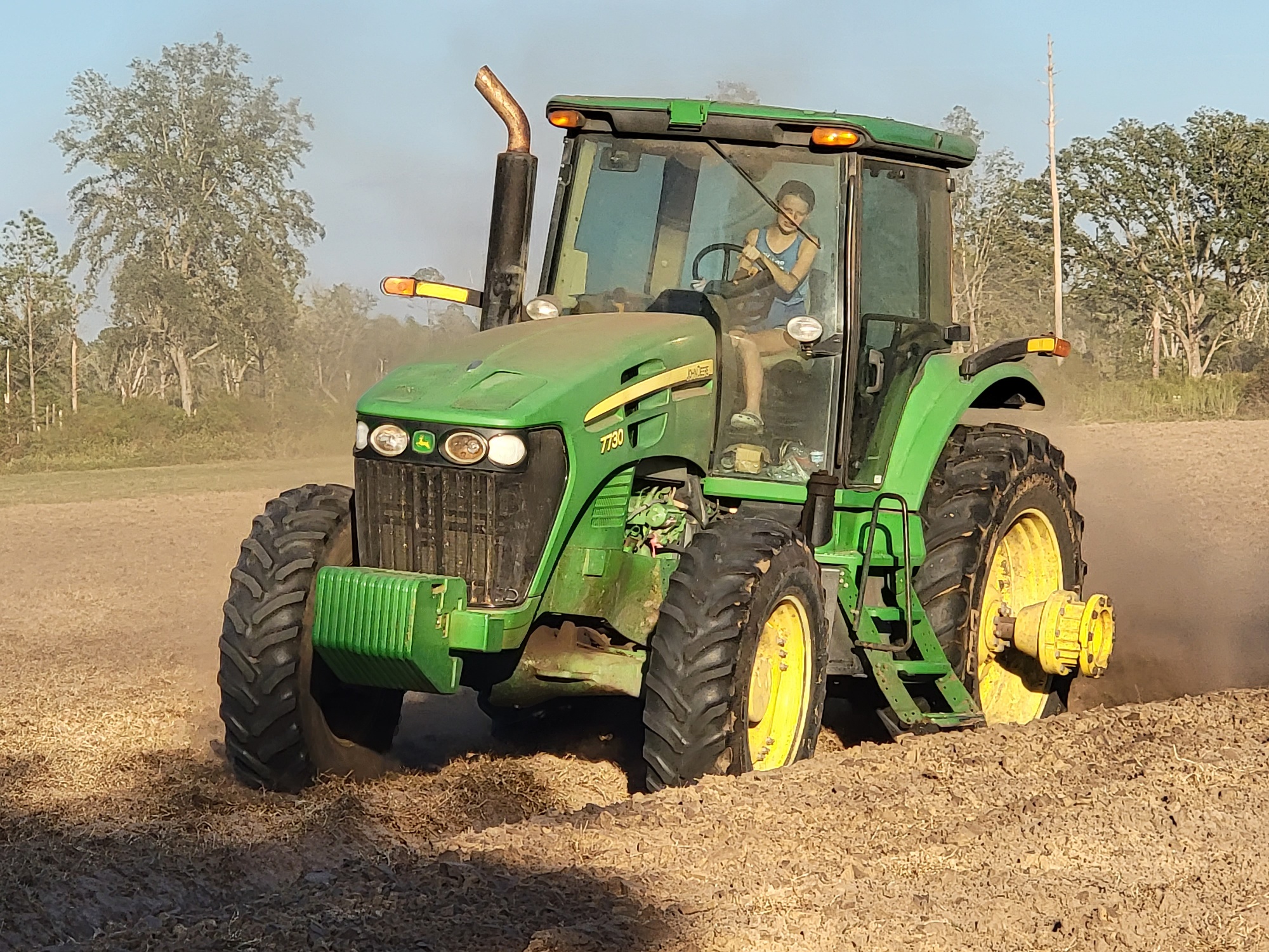 FLVS student Reagan driving a tractor on her family's farm.