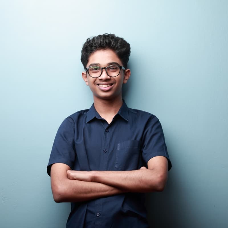 Smiling teenage student with glasses, arms crossed, representing a new FLVS student ready for online enrollment and quick start orientation.
